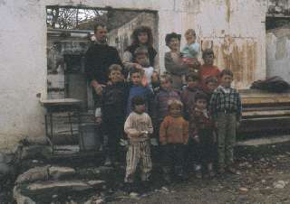 Albanische Familie vor ihrem zerstrten Haus
